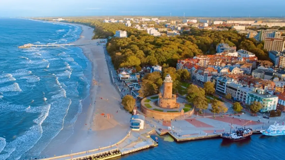 Widok na wybrzeże Bałtyku z plażą, molo, latarnią morską i miastem. To piękne wyspy na Bałtyku, gdzie można podziwiać architekturę i morze.