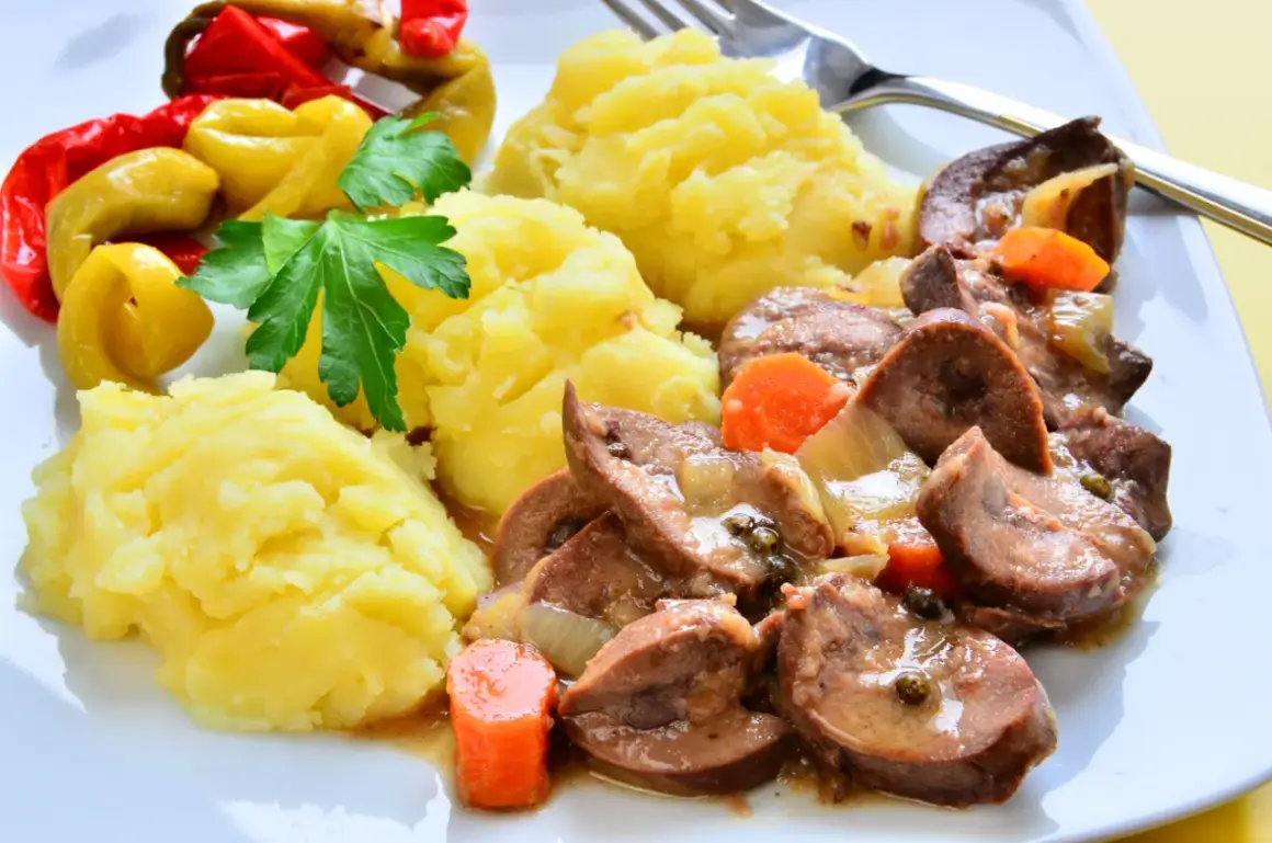 Cynaderki duszone z marchewką i cebulą, podane z puree ziemniaczanym i pikantnymi papryczkami. Pyszne danie, które warto spróbować!