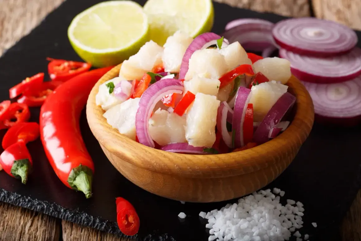 Pyszne ceviche co to? Świeża ryba, chili, czerwona cebula i limonka w drewnianej misce.