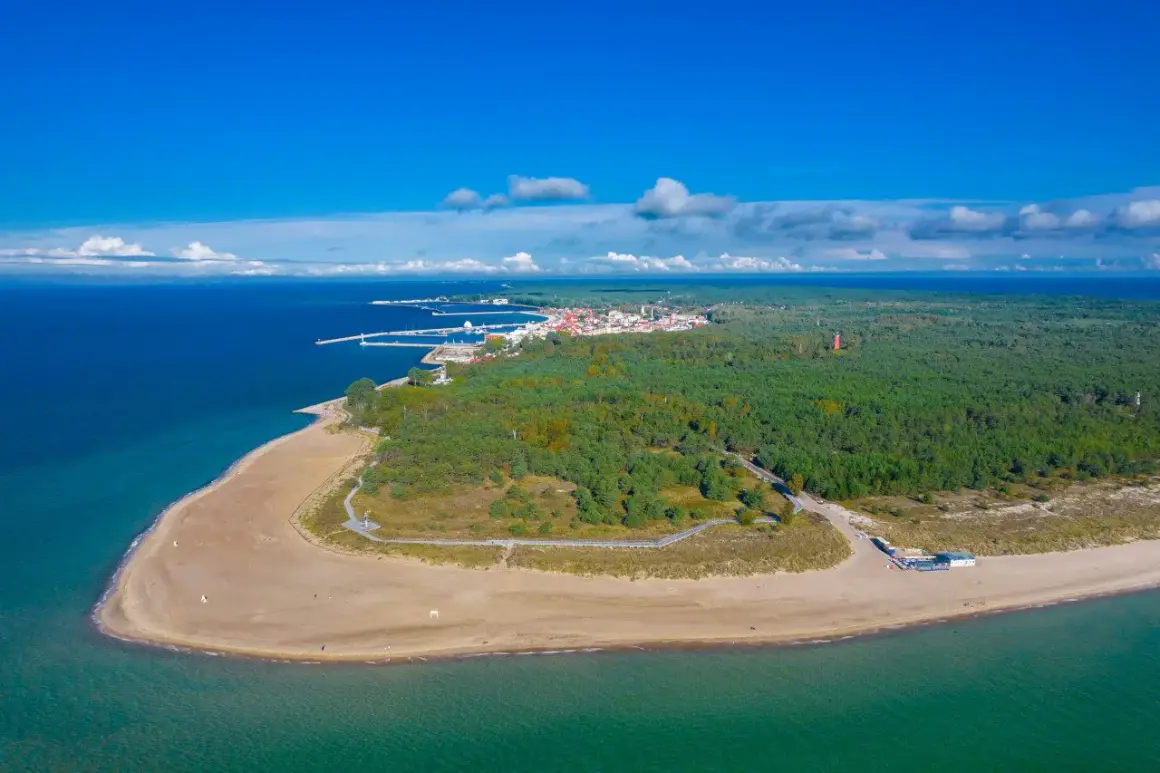 Widok z lotu ptaka na Półwysep Helski, gdzie leży Jastarnia. Piękna plaża, las i port w oddali.