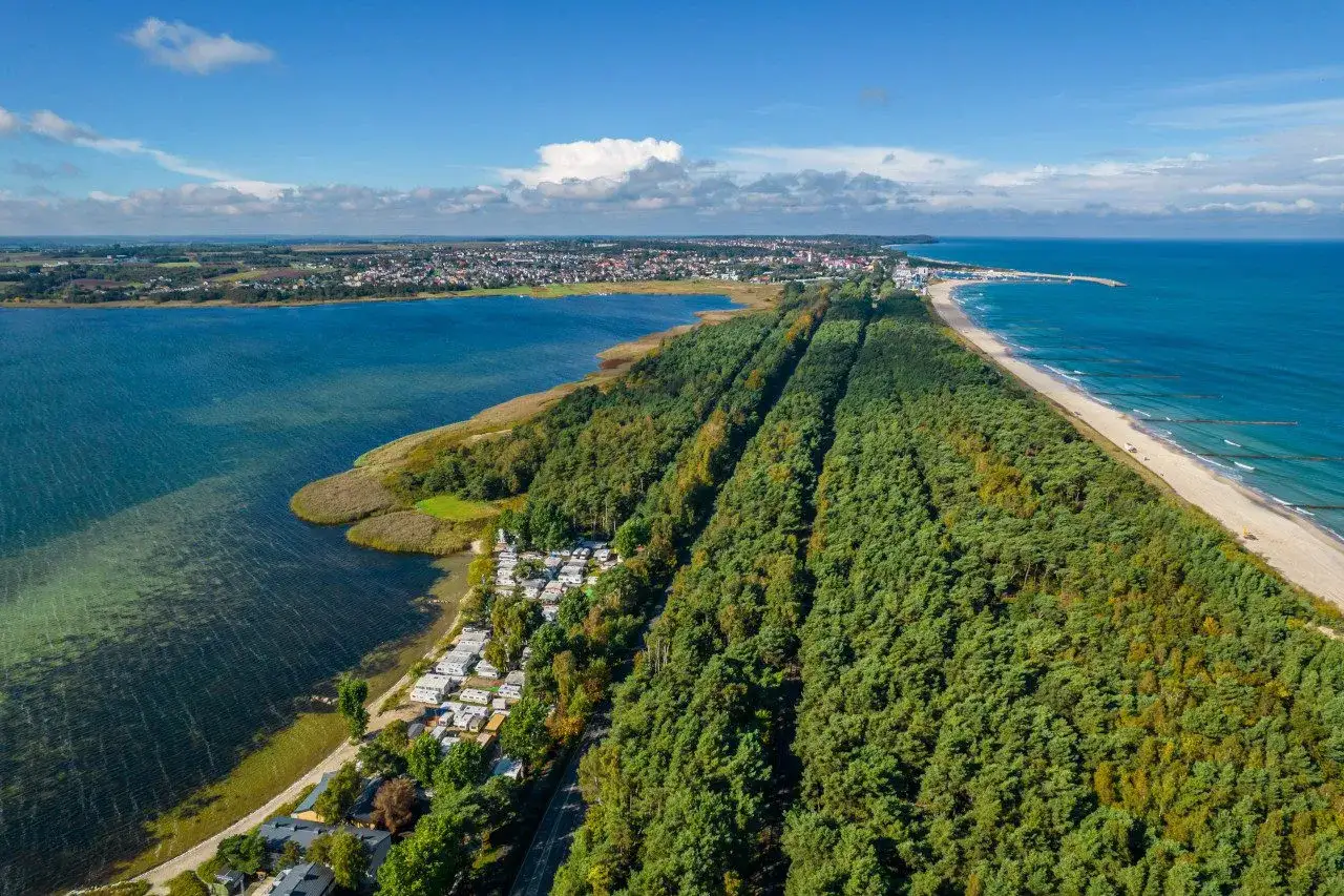 Malownicze wczasy na Helu: widok z lotu ptaka na kemping, las i plażę nad Bałtykiem.