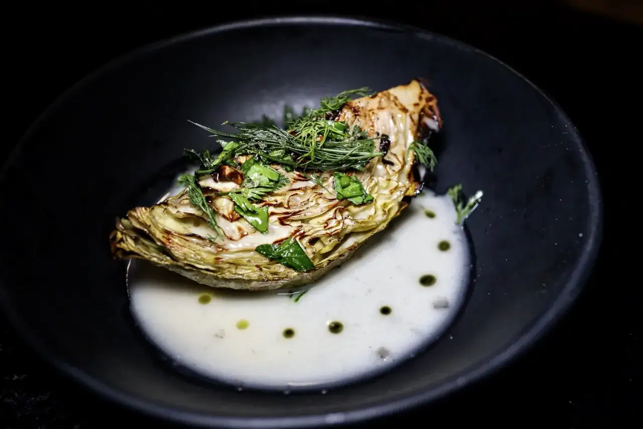 Pieczona kapusta z ziołami i kremowym sosem, przykład wykwintnej haute cuisine.