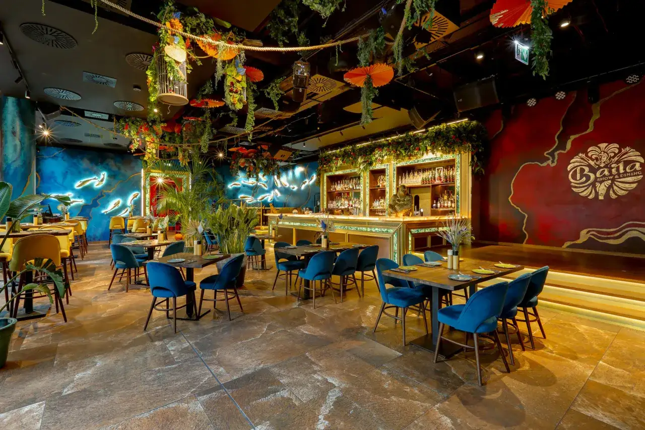 Egzotyczne wnętrze restauracji z neonowymi rybami, bujną roślinnością i barem. Idealne miejsce na romantyczną kolację, które może znaleźć się w rankingu restauracji Warszawa.