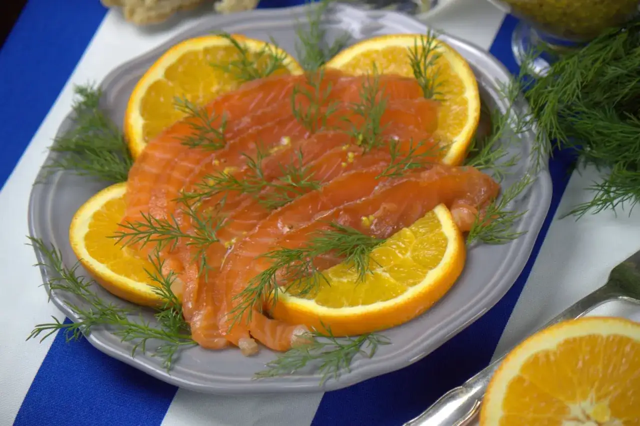 Pyszny łosoś w stylu gravlax, udekorowany plasterkami pomarańczy i świeżym koperkiem. Idealny na przystawkę, zgodnie z przepisem na gravlax.