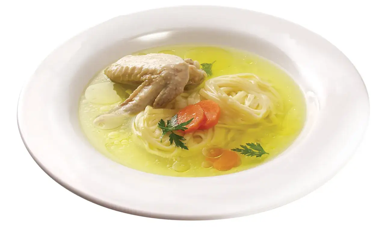 Aromaticzny rosół z makaronem, kawałkiem kurczaka i marchewką. Czy rosół jest zdrowy? Tak, to idealny posiłek regeneracyjny.