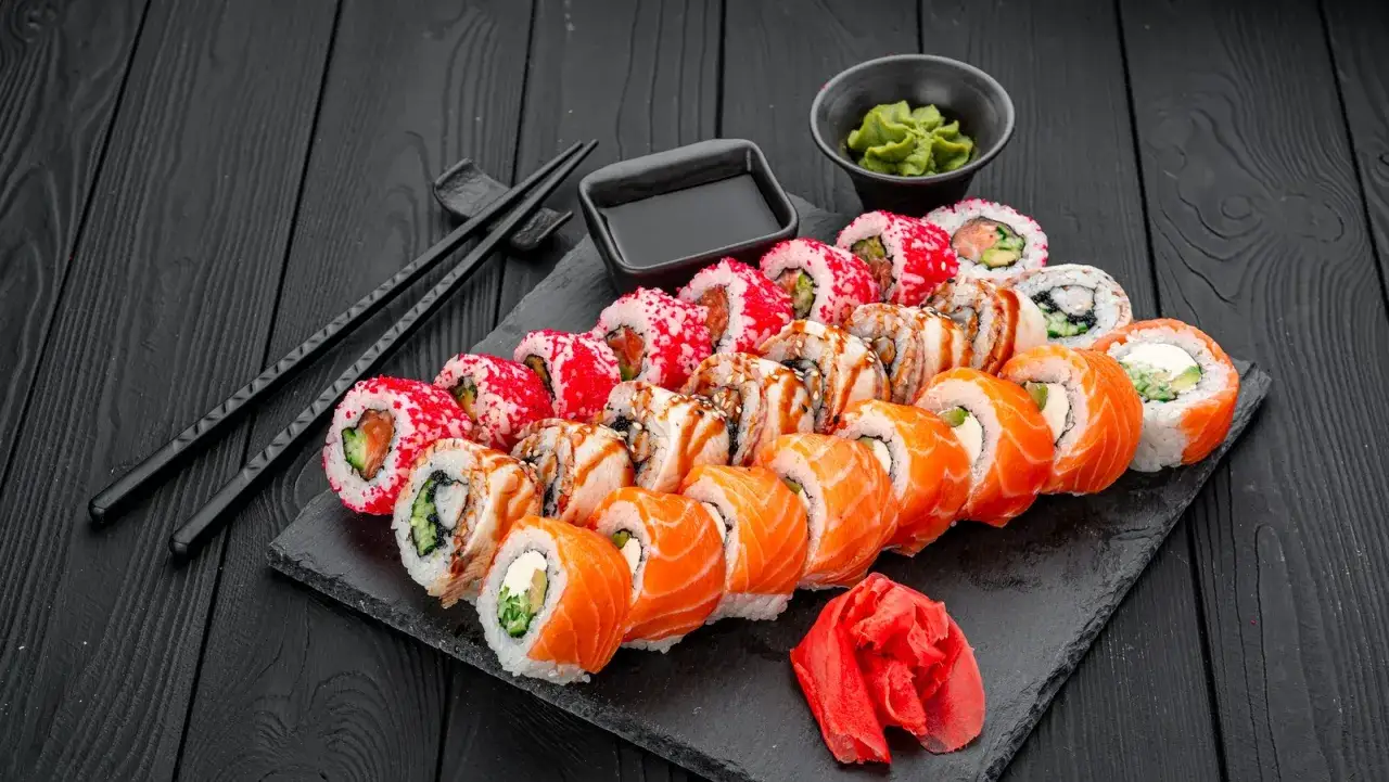 Zestaw sushi z łososiem, węgorzem i krewetkami, podany z wasabi, imbirem i sosem sojowym. Idealne z czym sushi.