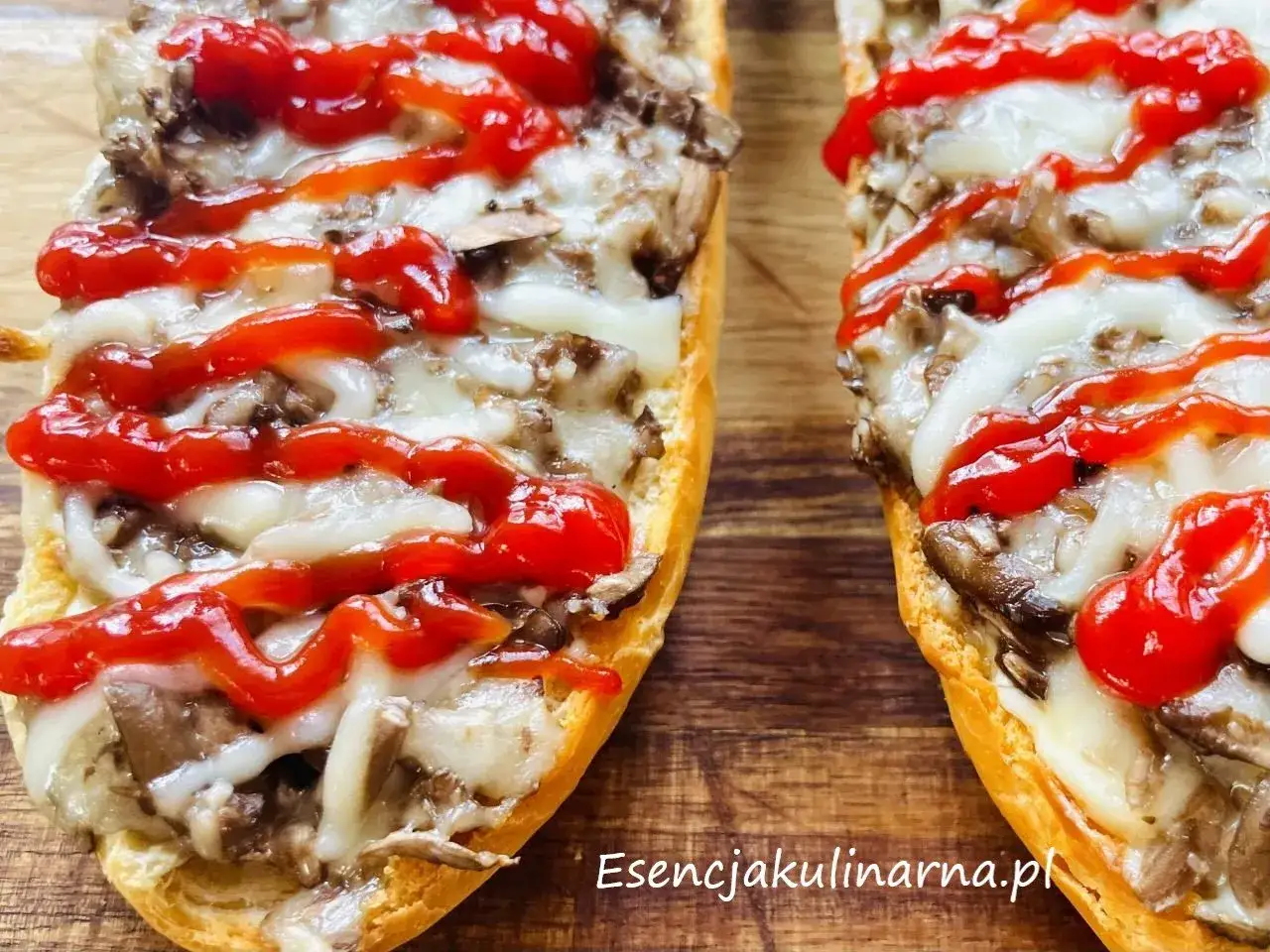 Pyszne domowe zapiekanki z piekarnika z pieczarkami i ciągnącym serem, polane keczupem.