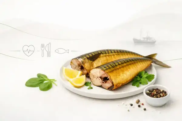 Dwie wędzone makrele na talerzu z cytryną i szpinakiem. Czy makrela wędzona jest zdrowa? Tak, to bogactwo kwasów omega-3.