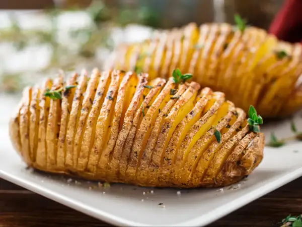 Ziemniaki hasselback, które Ania gotuje, wyglądają apetycznie. Delikatnie nacięte i upieczone, z ziołami na wierzchu.