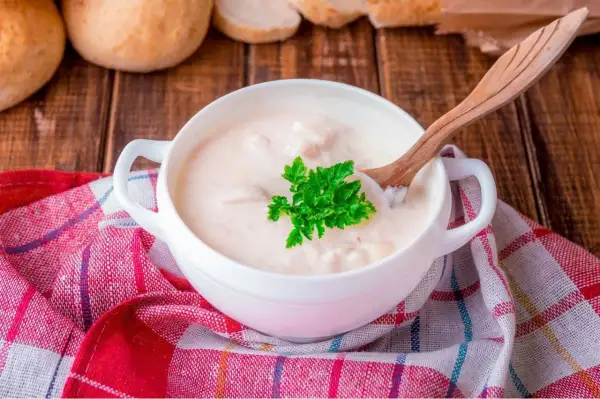 Kremowa zupa z kaczką, doprawiona aromatycznym tłuszczem z kaczki, podana z natką pietruszki i pieczywem.