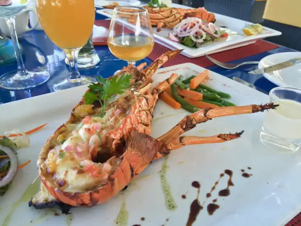 Wykwintne mauritius jedzenie: grillowany homar z warzywami i drinkami. Pyszny posiłek na wakacjach.